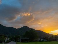 Gleißender Sonnenuntergang hinter den Bergen mit leuchtenden Wolken